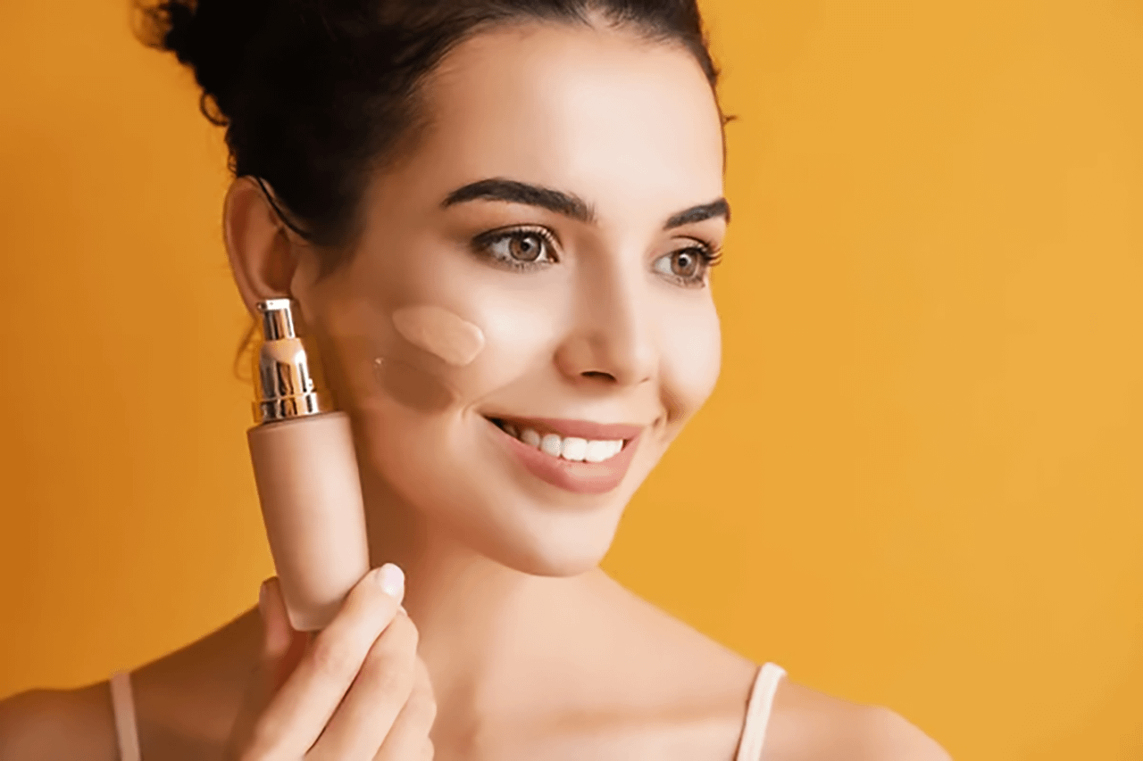 Donna che applica il fondotinta come base per il baking make-up