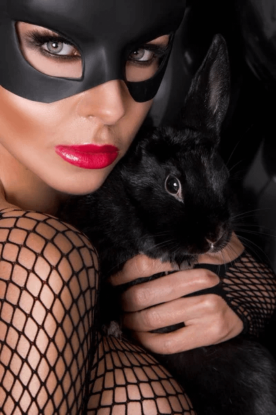 Donna in stile Playboy con un coniglio nero che rappresenta l'evoluzione del comportamento maschile.