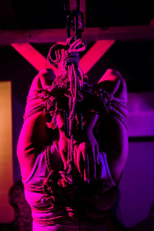 Donna sospesa in posizione bondage artistico, rappresentazione visiva del galateo sessuale secondo lo stile Pommenor.