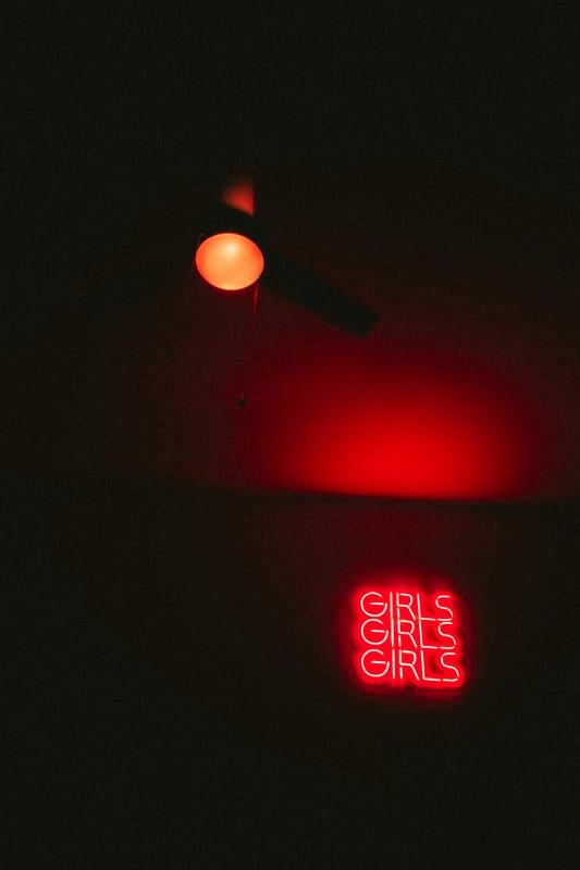 Insegna al neon rossa con la scritta "GIRLS" che richiama l’estetica provocatoria di phica.net e mia moglie.