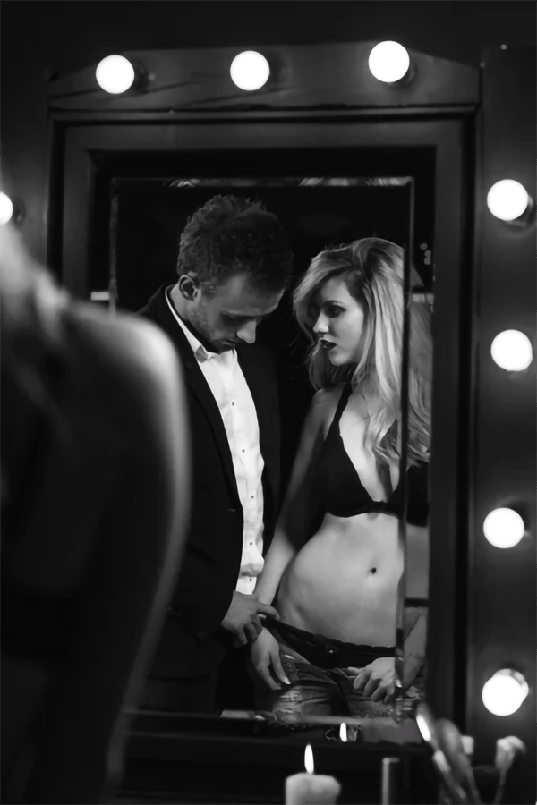 Coppia in atteggiamento intimo davanti a uno specchio, esplorando la dinamica della sveltina e desiderio.