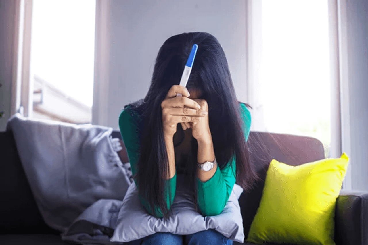 Donna in stato di sconforto dopo una gravidanza inaspettata nonostante il contraccettivo permanente, Pommenor.