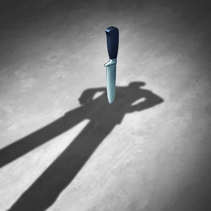 Un coltello con un'ombra di una donna misteriosa che suggerisce il fascino delle donne con una doppia vita.