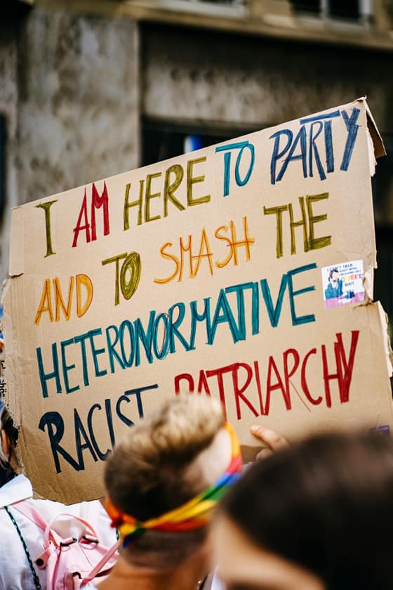 Cartello di protesta contro la discriminazione dei transgender che critica il patriarcato e l'eteronormatività.