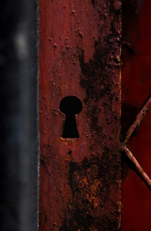 Primo piano di una serratura antica su una superficie arrugginita, simbolo del desiderio di anonimato e della protezione della privacy.